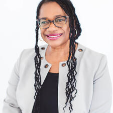 headshot of Sheryl smiling at the camera